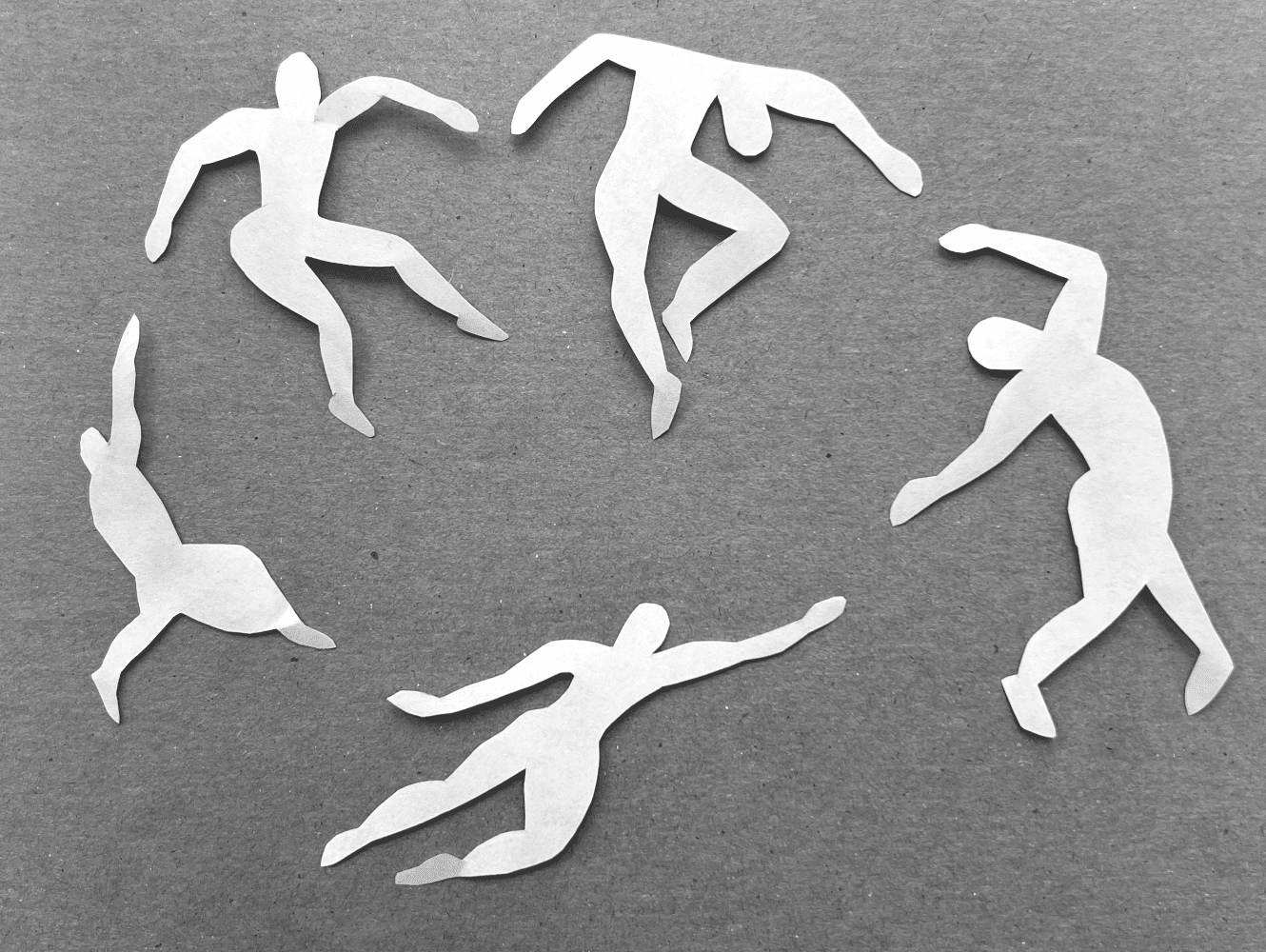 Five white paper cutout silhouettes of abstract dancing figures arranged in a circular pattern on a gray background.